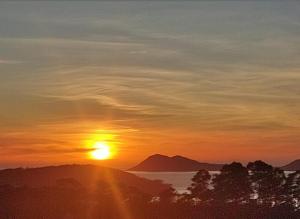 a sunset with the sun setting over the water at Eira de Mantoño in Mantoño +2 photos