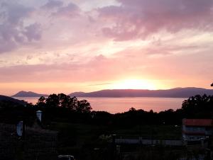 a sunset over the water with mountains in the background at Eira de Mantoño in Mantoño