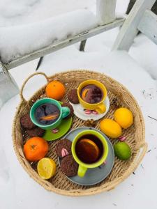 a basket with cookies and oranges and two cups of tea at Miętowy domek in Jagodne