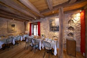 a restaurant with tables and chairs in a stone wall at La Maison d'Artgile in Zimmersheim