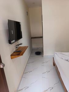 a room with a television on a wall with a tiled floor at Silver Shark Boutique Villas in Ajgaon