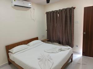 a bedroom with a white bed with a window at Silver Shark Boutique Villas in Ajgaon