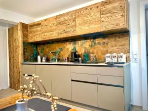 a kitchen with a sink and wooden cabinets at SeeChalet Hallstatt in Bad Goisern