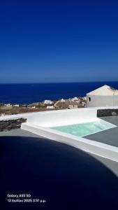 a swimming pool with the ocean in the background at Anemos Mill House in Imerovigli