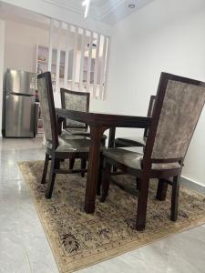 a wooden table and two chairs and a refrigerator at The Nirvana Place in Nairobi