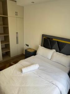 a white bed with a towel on top of it at The Nirvana Place in Nairobi