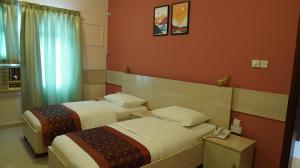 a hotel room with two beds and a telephone at Hotel Summersands Al Wadi Al kabir in Muscat +40 photos