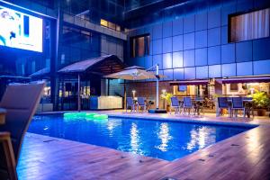a swimming pool with tables and chairs in a building at Hotel Lubumbashi in Lubumbashi