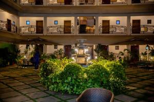a building with a courtyard with plants and a chair at Hotel Lubumbashi in Lubumbashi