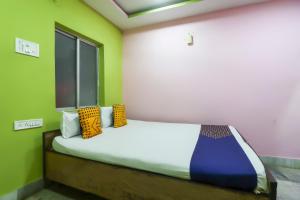 a bedroom with a bed with colorful pillows on it at Hotel O Bright in Jamshedpur +21 photos