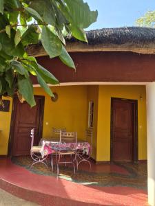 a porch of a house with a table and chairs at keur MaÏ et Mao in Somone
