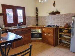a kitchen with wooden cabinets and a stove top oven at keur MaÏ et Mao in Somone