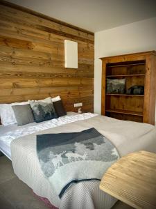 a bedroom with a bed and a wooden wall at SeeChalet Hallstatt in Bad Goisern