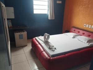 a bed with a red frame in a room at Motel pousada Zafira in Salvador +4 photos