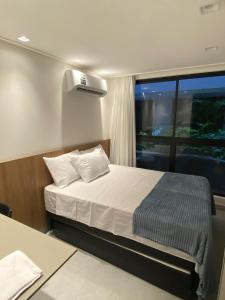 a small bedroom with a bed and a window at Flat Hit Cabo Branco in João Pessoa +22 photos