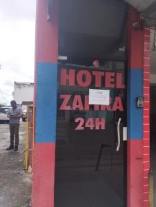 a man standing outside of a hotel zena zena at Motel pousada Zafira in Salvador