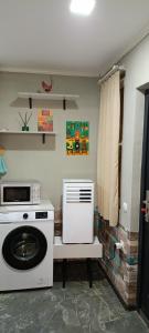 a kitchen with a washing machine and a microwave at Welcome Guests in Tbilisi City