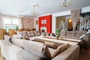 a living room with couches and a table at Rezydencja Florina - Willa z prywatnym basenem, jacuzzi i kortem tenisowym in Rogóźno