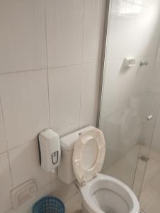 a white bathroom with a toilet and a shower at Motel pousada Zafira in Salvador