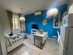 a living room with blue walls and a table at Luna D'Argento Apartment in Porto Ercole