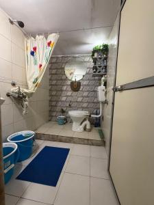 a small bathroom with a toilet and a door at Sun Bloom in Mumbai