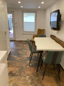 a room with a table and chairs and a tv at Therapiescheune Egsdorf - Monteurwohnungen in Egsdorf