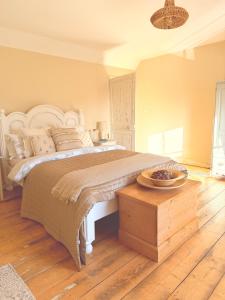 a bedroom with a large bed and a wooden table at Beehive Cottage in Beccles