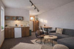 a living room with a couch and a table and a kitchen at Piemonti Bešeňová in Bešeňová