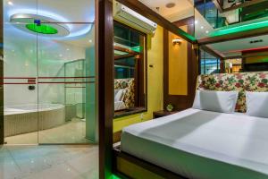 a bedroom with a bed and a shower and a tub at Status Motel in Serra