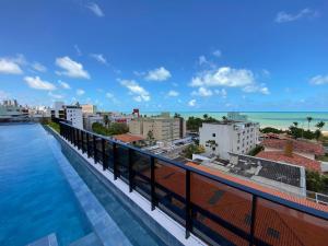 a balcony with a view of the ocean and buildings at Flat Hit Cabo Branco in João Pessoa
