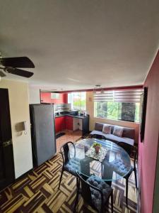 a living room with a glass table and a kitchen at Apartamento Acogedor, tranquilo y privado in Lima