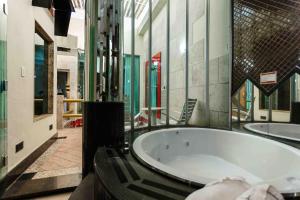 a large bathroom with a tub in a building at Status Motel in Serra +4 photos