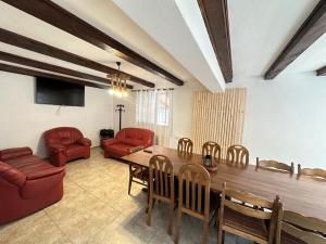 a living room with a wooden table and red chairs at Casa de vacanta Cabana Toto in Sebeşu de Jos