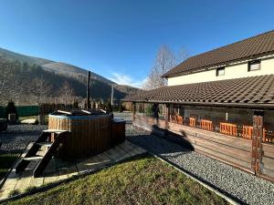 a building with a wooden fence next to a house at Casa de vacanta Cabana Toto in Sebeşu de Jos