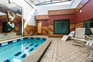 a swimming pool with chairs and a table and a swimming pool at Status Motel in Serra