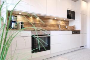 a kitchen with white cabinets and a stove at Kapitänshaus an der Friedrichsschleuse in Friedrichsschleuse +20 photos