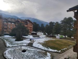 a park with snow on the ground and buildings at Tranquility Apartment Pirin Golf in Razlog