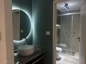 a bathroom with a sink and a toilet and a mirror at Apart Lunge in Córdoba +24 photos
