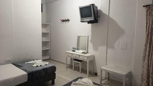 a room with a bed and a mirror and a tv at Hotel Montecarlo by Croma in Santiago +34 photos