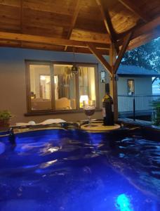 a swimming pool with a bottle of wine and a glass at Upper Gelli Luxury Holiday Lodge, Converted Dairy & Cosy Shepherds Huts in Welshpool