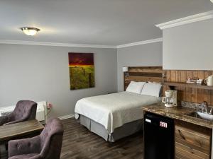 a hotel room with a bed and a sink at Augustus Jane Inn in Rocky Harbour