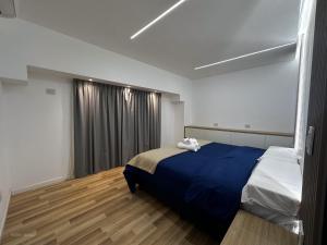 a bedroom with a bed with a blue blanket at Apart Lunge in Córdoba