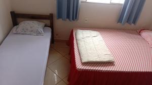 two beds in a small room with blue curtains at Vanildo Oliveira in Uberlândia