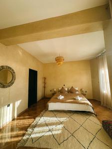 a bedroom with a bed and a large rug at Catamaran Surf House in Agadir nʼ Aït Sa
