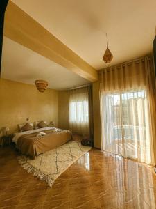 a bedroom with a bed and a large window at Catamaran Surf House in Agadir nʼ Aït Sa +39 photos