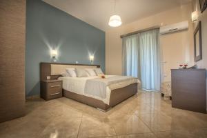 a bedroom with a large bed and a large window at Reparo Studios in Lithakia