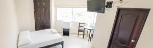 a living room with a tv on a wall at Hotel CATAYAR in Santa Marta