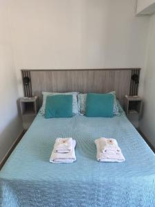 two towels on a bed with two pillows on it at Departamentos Le & Lo in Cipolletti
