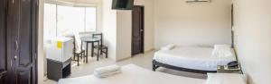 a hospital room with two beds and a mirror at Hotel CATAYAR in Santa Marta