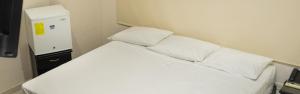 a bed with white sheets and pillows in a room at Hotel CATAYAR in Santa Marta